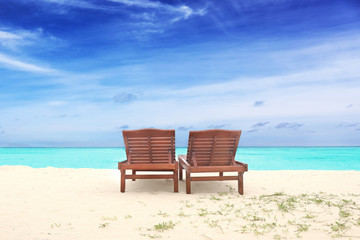 Sun loungers on beach in summer day
