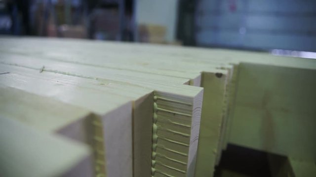 boards cut out deck. Cut log into planks and beams using lines of processing logs. Close up view of modern sawmill product