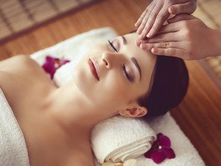 Beautiful girl getting face lifting massage in spa salon. Health care, rejuvenation and relaxation concept.