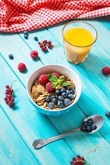 Multigrain wholewheat healthy cereals with fresh berry and a glass of juice for breakfast