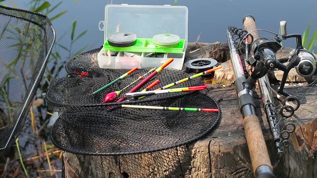 A set of fishing tackles and baits on the background of a lake