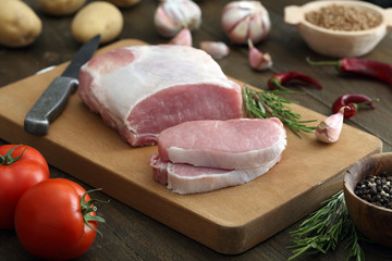 carne cruda di porco o maiale su sfondo tavolo di cucina rustico