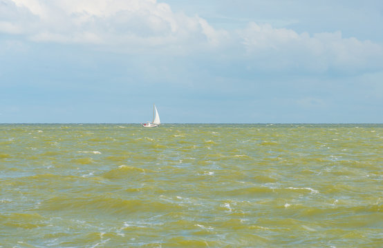 Sailing boat sailing over a stormy lake in summer