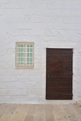 Obraz na płótnie Canvas Traditional facade of south adriatic sea house with door and window minimalist decorated in small village of Monopoli, south Italy