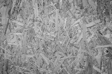 Close-up of a particle board background texture with vignetting in black and white.