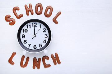 Obraz na płótnie Canvas School Lunch written by chocolate cookies alphabet with round clock