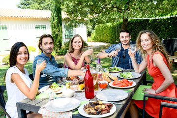 Fototapeta na wymiar group of friends having fun picnic lunch party outdoor in backyard during summer holiday vacation