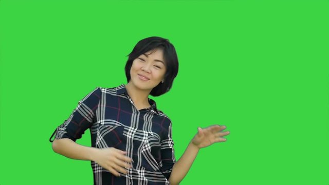 Female engineer with a jrange hemlet and construction plan trying to talk with somebody far away on a Green Screen, Chroma Key