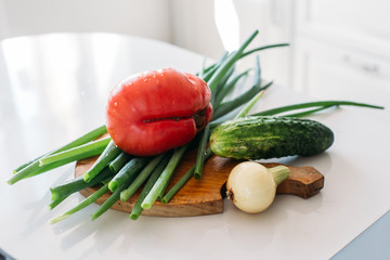 Organic deformed but healthy and non gmo vegetables from garden, picked up and harvested with love and care, not using chemicals, tomato, green onion and cucumber