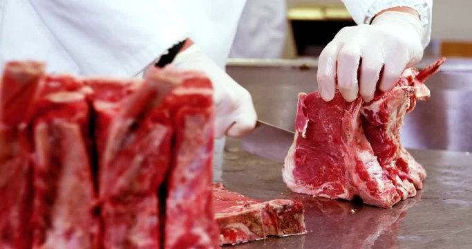 Mid section of butcher slicing meat