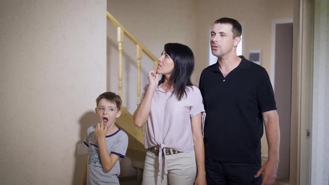 Young Family With Son Exploring New Spacious House And Talking