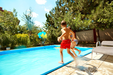 Children jump into the pool in the summer.