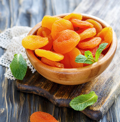 Dried apricots in wooden bowl.
