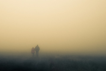 Couple in the fog on meadow