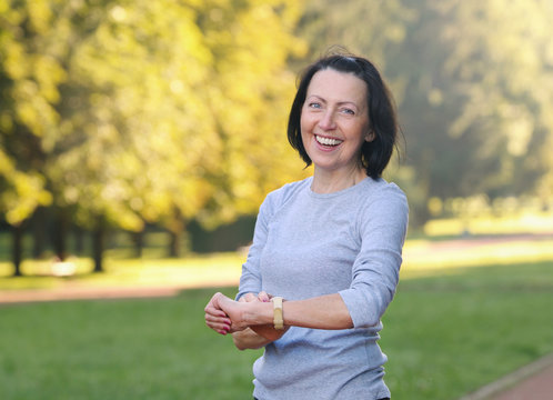 Portrait of mature woman cheking the pulse after jog in the park