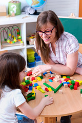 Preschool Teacher and Kid Playing with Wooden Building Blocks