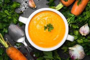 Carrot cream-soup on black table.