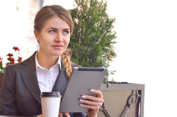 Fototapeta premium Pensive young woman reading her touchscreen tablet