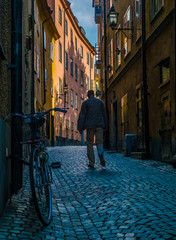 Old man Walks along a Cobbled Street