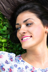 Fototapeta premium Young beautiful woman lying on grass 