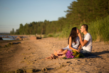 A young couple in love, on the shore of the Bay at sunset