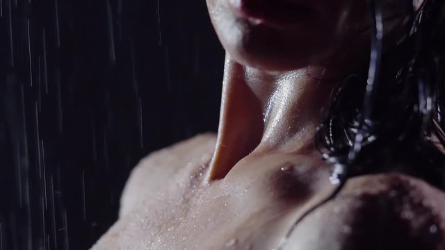 close-up. naked girl in the shower. the water flows over the smooth skin. big lips and beautiful silicone Breasts compressed hands with long fingers