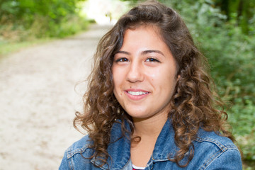 Teenage girl smiling outside in nature