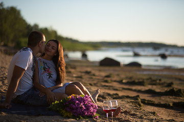 A young couple in love, on the shore of the Bay at sunset