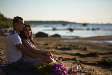A young couple in love, on the shore of the Bay at sunset