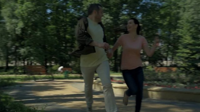 Joyful couple running in the park