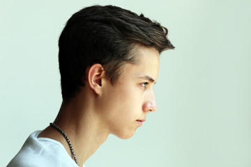 Young man profile face on a grey background