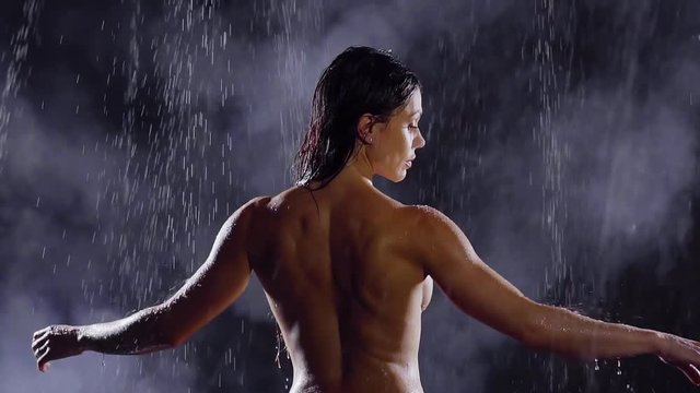 sexy middle-aged woman standing in the rain naked. his arms around and meditate. little seen big beautiful Breasts