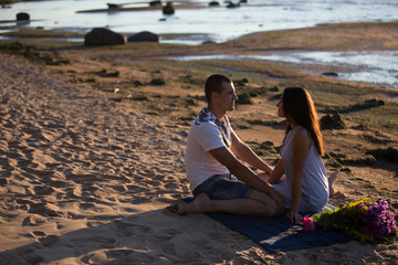 A young couple in love, on the shore of the Bay at sunset