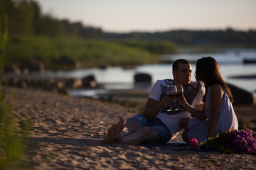 A young couple in love, on the shore of the Bay at sunset