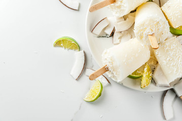 Summer desserts. Vegan diet food. Coconut and lime home fruit ice cream popsicles on a stick. On...