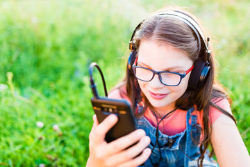 Teen girl listening to music with her retro  headphones outdoor