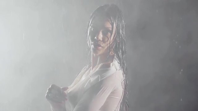 sexy girl semi Nude covering his nakedness with white shirt in a thick fog in the rain at night