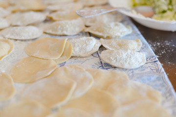 Making dumplings, ravioli busy kitchen table background, closeup top side view