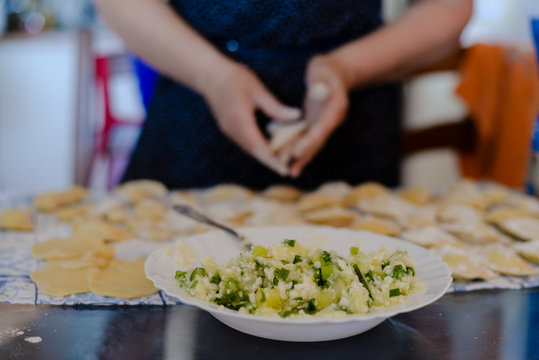 Making dumplings, ravioli busy kitchen table background, closeup top side view