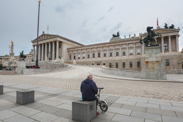 Obraz premium Tourists near the building of the Austrian Parliament on a cloudy summer day. Blurred Faces, Unrecognizable Faces. in Vienna, Austria.