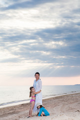 family mother and two daughters on a sandy beach under a cloudy sky