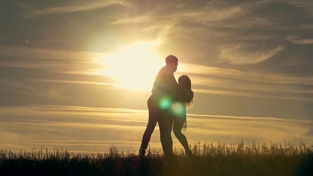 Silhouette of a young couple running towards each other. The concept of love.