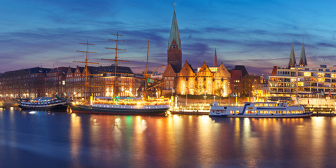 Embankment of the Weser River and Protestant Lutheran Saint Martin Church in the old town of Bremen, Germany. Night panoramic view.