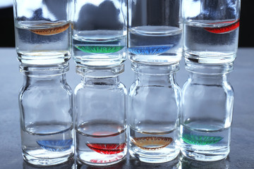 Bottles with contact lenses on gray table