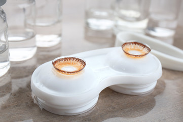 Container with color contact lenses on table
