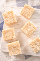 White cutting board with rice treats on light napkin