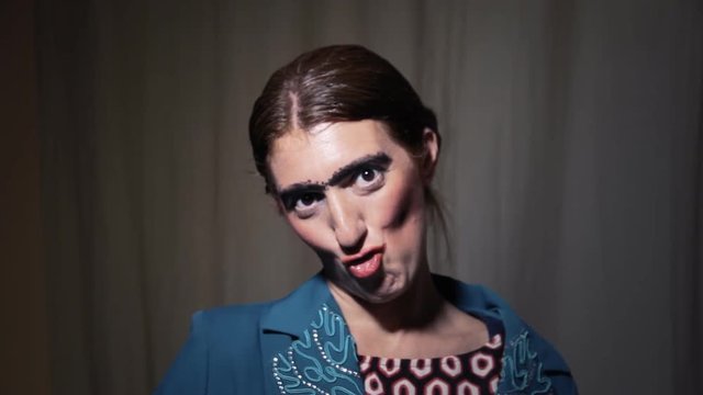 An ugly woman hiding her face behind a fan, and slowly appearing.
