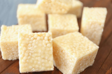 Wooden cutting board with cubes of rice treats, closeup