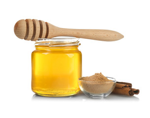Honey in jar, dipper, cinnamon and bowl with powder on white background