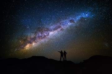 Fototapeta na wymiar Landscape with Milky Way. Night sky with stars and silhouette of a couple on the mountain.